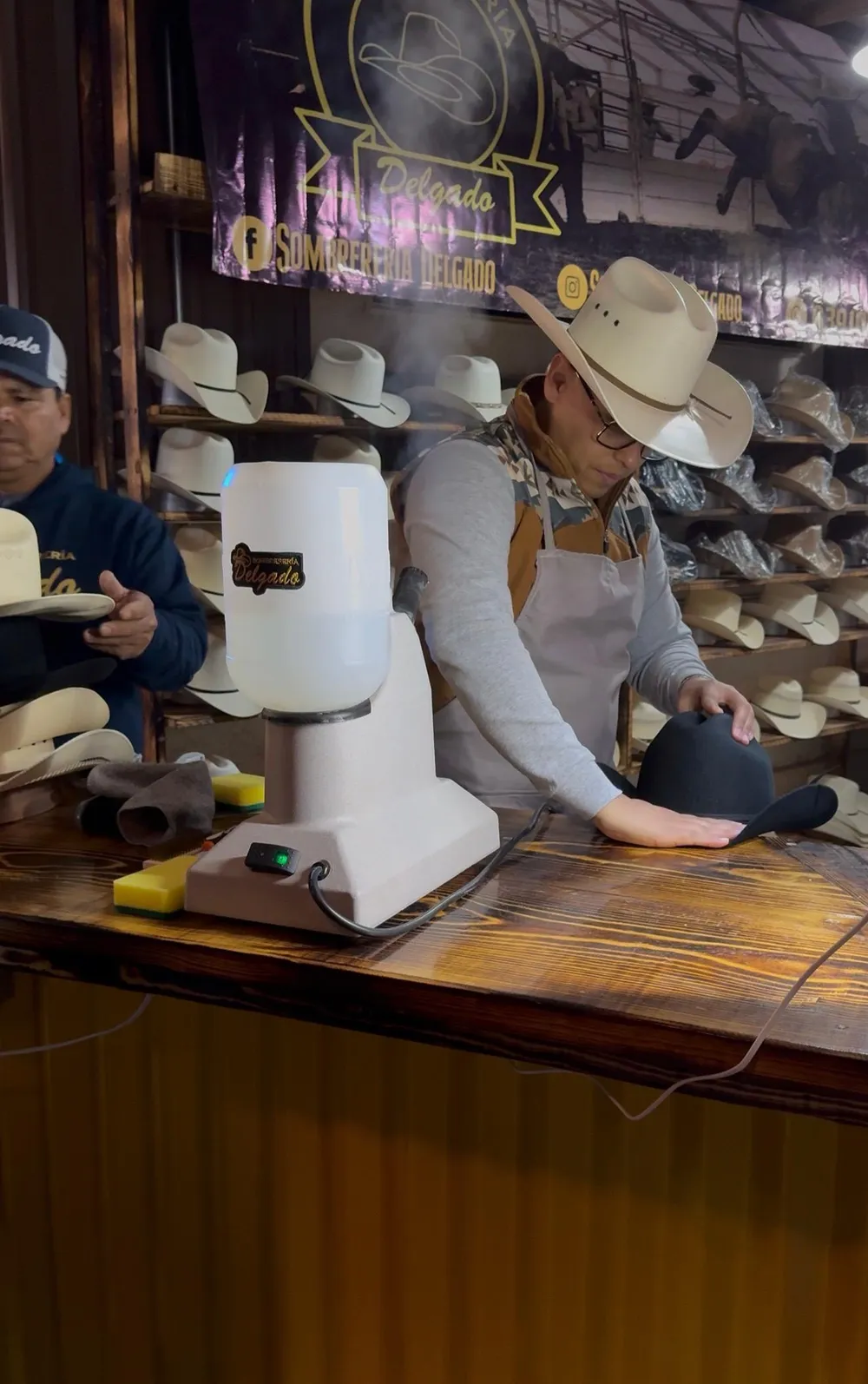 Maestro hormando un sombrero con vaporera en el taller de Sombrerería Delgado